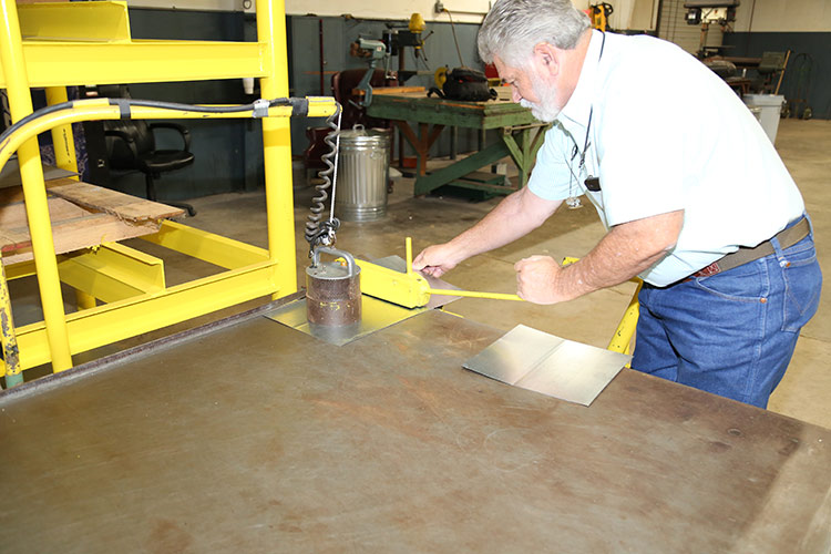 Jim Patterson, owner, working on a machine.