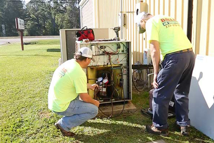 Employees working on air conditioning unit.